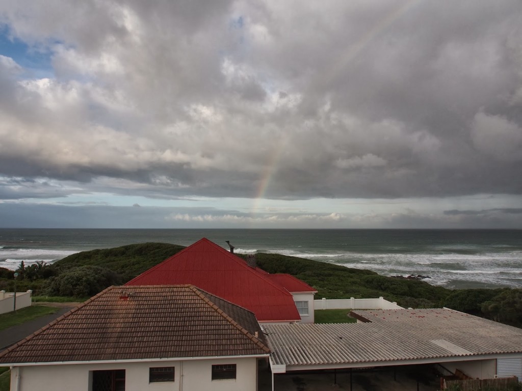 Rainbow arising from the ocean in morning.