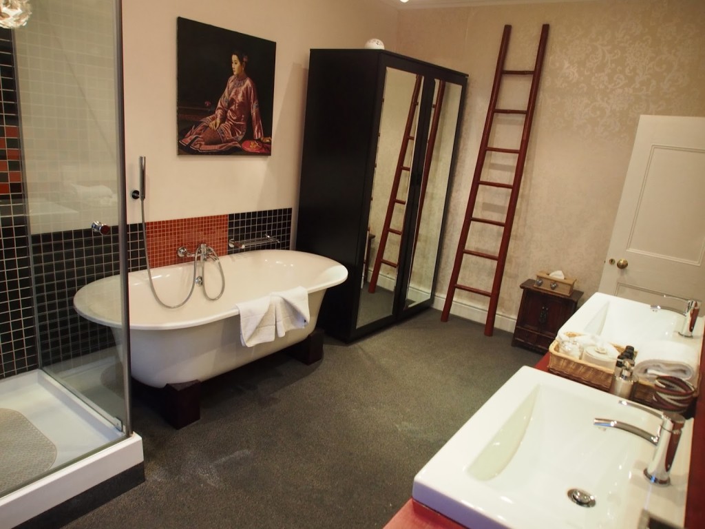 Spacious bathroom with tub and separate shower and double basins.